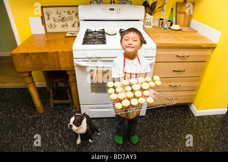 Jeune garçon faisant cupcakes Banque D'Images