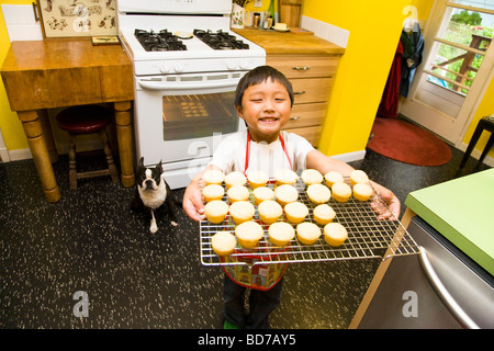 Jeune garçon faisant cupcakes Banque D'Images