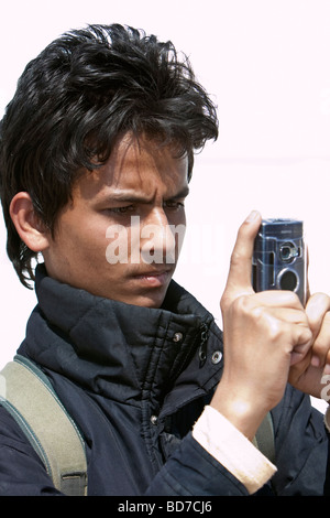 Bodhnath, au Népal. Jeune homme népalais au Stupa de Bodhnath bouddhiste en photo avec un téléphone cellulaire. Banque D'Images