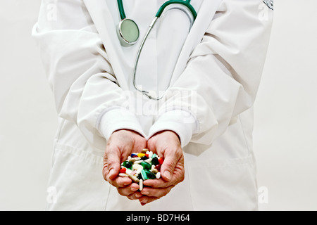 Une femme en blouse de médecins holding pills and capsules de médecine Banque D'Images