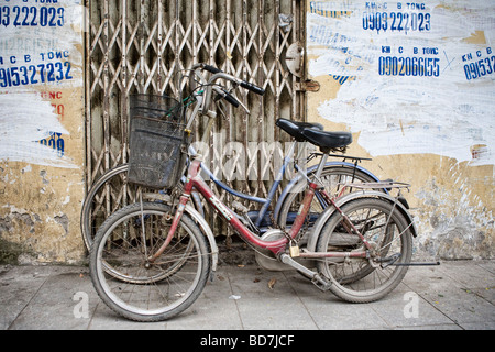 Les vélos appuyé contre un mur à Hanoi Banque D'Images