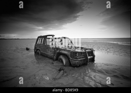 Voiture abandonnée partiellement enterré dans le sable de la baie de Morecambe Banque D'Images