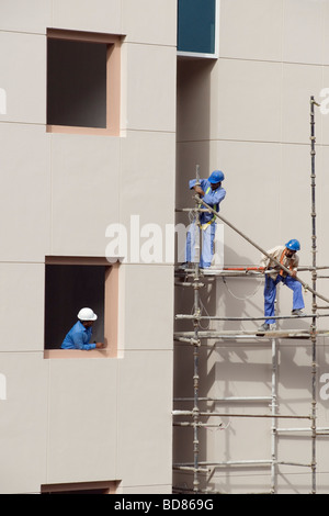 Les travailleurs de la construction sur des échafaudages à DUBAÏ, ÉMIRATS ARABES UNIS Banque D'Images