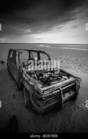 Prise de vue au grand angle de voiture abandonnée partiellement enterré dans le sable de la baie de Morecambe Banque D'Images