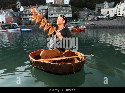 Le poisson fumé et historien maritime Mike Smylie coracle en harengs fumés avec à l'hareng Clovelly, Devon UK Festival Banque D'Images