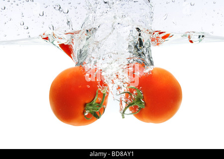 Les tomates rouges sous l'eau éclaboussant Banque D'Images