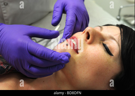 Une femme a sa lèvre inférieure percée d'un goujon Banque D'Images