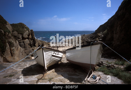 Deux petits bateaux de pêche sur la rive dans la station balnéaire de Porthgwarra cornish Cove sur la côte sud-ouest de l'Angleterre Cornwall chemin Banque D'Images