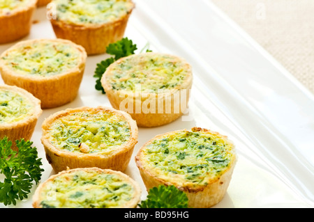 Assiette de nombreux petits mini quiches apéritifs Banque D'Images