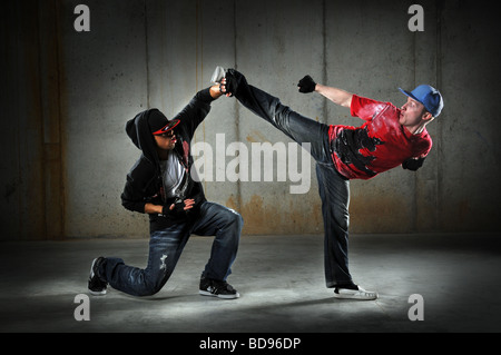 Danse hip hop hommes effectuant un mouvement d'arts martiaux Banque D'Images