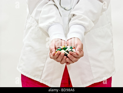 Une femme en blouse de médecins holding pills and capsules de médecine Banque D'Images