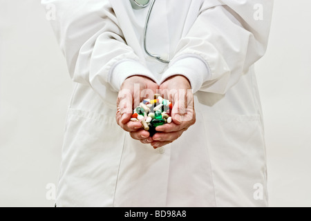 Une femme en blouse de médecins holding pills and capsules de médecine Banque D'Images