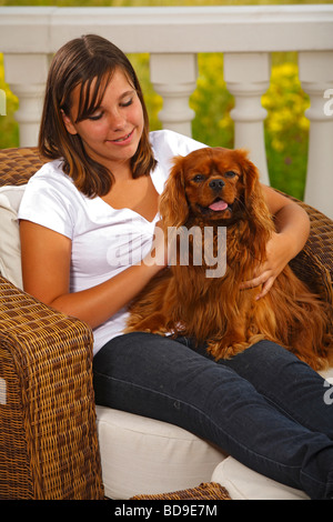 Fille avec Cavalier King Charles Spaniel Ruby caressant caresse Banque D'Images