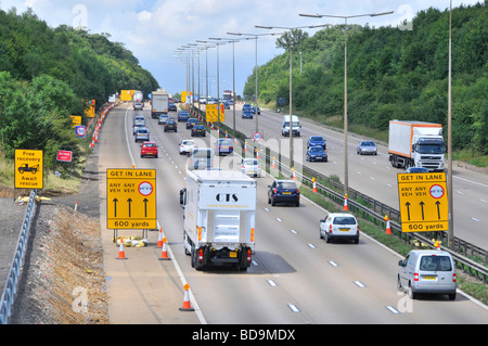 L'élargissement de l'autoroute M25 signes de commutation lane à l'approche des travaux routiers Banque D'Images