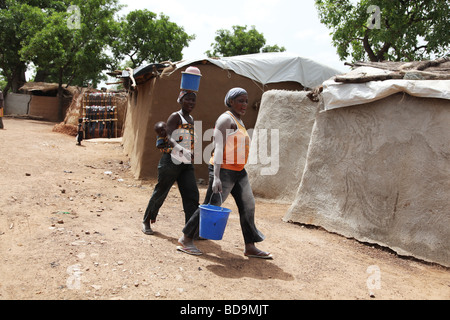 L'exploitation aurifère dans le Nord du Ghana, Terkwe.Femmes marchant avec la poussière dans leurs visages de travail après avoir été le broyage de roches. Banque D'Images