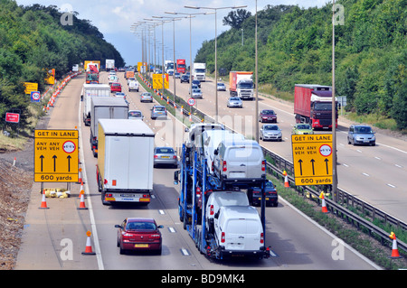 L'élargissement de l'autoroute M25 signes de commutation lane à l'approche des travaux routiers Banque D'Images