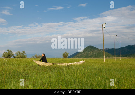 Une femme assise dans un bateau, le lac de Skadar, Monténégro Banque D'Images