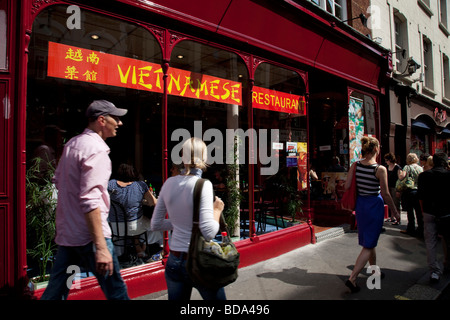 Scène de rue dans le quartier chinois de Londres. Les gens passent devant un restaurant vietnamien Banque D'Images