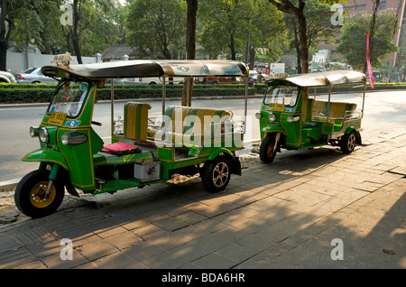 Deux taxis Tuk Tuk récemment peints stationnés sur le pavé de Bangkok Thaïlande Banque D'Images