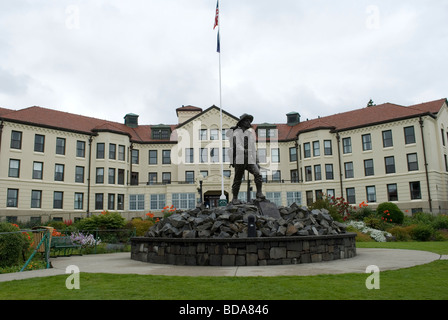 La Statue d'un prospecteur avec en arrière-plan la maison des pionniers de Sitka, Sitka, Alaska Banque D'Images