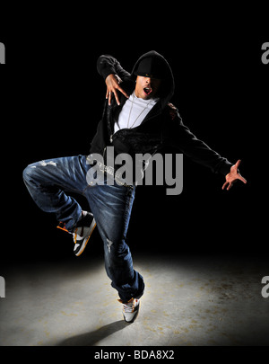 Style hip hop dancer avec capot sur un fond sombre avec Spotlight Banque D'Images