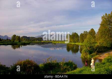 La pêche, tandis que les enfants, grand-père a l'air sur la rivière Alouette, Pitt Meadows, BC Banque D'Images