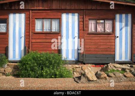 La côte, l'île de Wight, cabines de plage en bois avec portes rayé bleu et blanc Banque D'Images