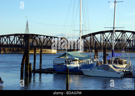 Les bateaux de plaisance s'asseoir amarré en face de l'ancien pont ferroviaire sur la rivière Pitt, Port Coquitlam, BC Banque D'Images