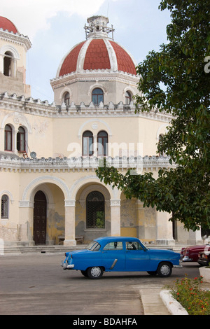 Vieille voiture devant poteaux funéraires de Cristobal de Colon Cemeterio, Vedado, La Havane, Cuba Banque D'Images