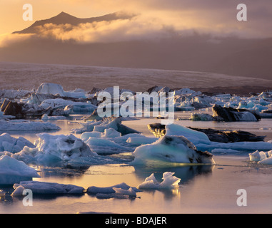 Soleil de minuit illuminant la glace flottant dans Jökulsarlön l'Europe du sud de l'Islande Banque D'Images