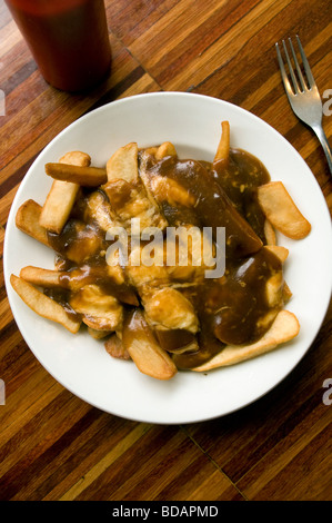 Une plaque de fraîchement servi la poutine - une délicatesse canadien composé de frites, sauce et fromage - dans un restaurant à Toronto, au Canada. Banque D'Images