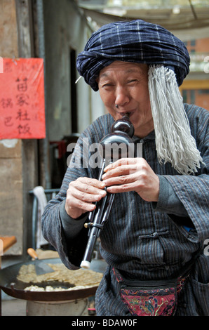 Musicien jouant d'un instrument à vent Hulusi ancienne ville de Fenghuang Chine Hunan Banque D'Images