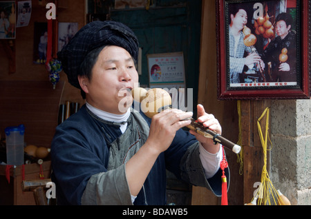 Propriétaire de la lecture d'un instrument à vent Hulusi ancienne ville de Fenghuang Chine Hunan Banque D'Images