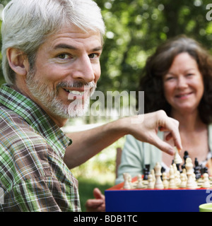 Mature couple jouant aux échecs et souriant Banque D'Images