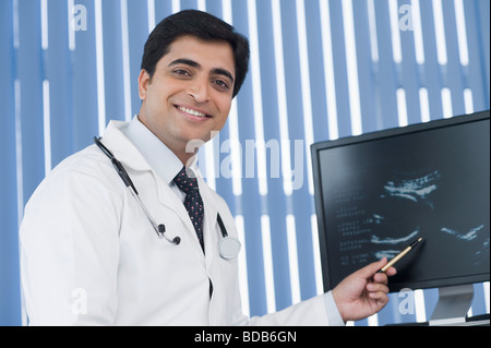 Homme médecin examinant des ultrasons et smiling Banque D'Images