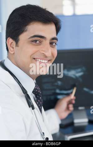 Homme médecin examinant des ultrasons et smiling Banque D'Images