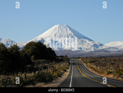 Vue panoramique de l'autoroute principale menant à travers la forêt en de magnifiques couverts de neige d'activité volcanique Mont Ruapehu en Nouvelle-Zélande. Banque D'Images