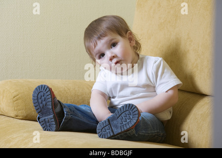 Portrait of young boy sitting on sofa Banque D'Images