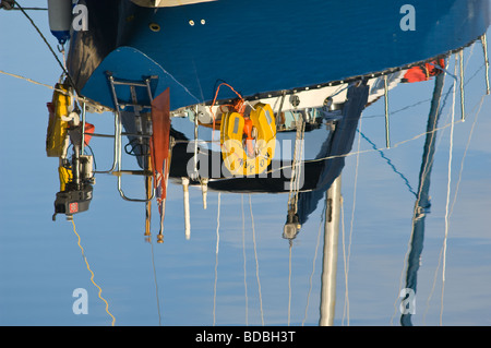 Reflet dans un lac encore du gréement d'un bateau à voile. Banque D'Images