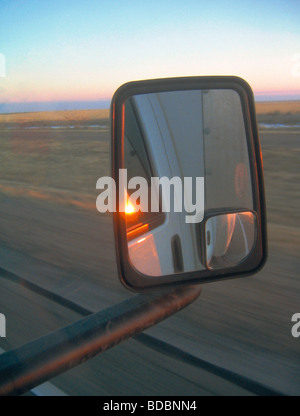 Coucher du soleil vu dans un rétroviseur latéral d'un camion Banque D'Images