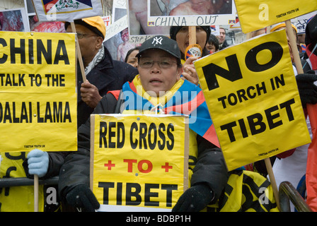 La police des manifestants en Pro-Tibet stylo à partir de la route avec des pancartes comme la flamme olympique de Beijing s'effectue à travers Londres. Banque D'Images