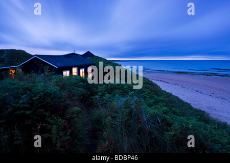 Chalet côté plage allumé sur une fin de soirée d'été dans les dunes entre les villages de Embleton et faible Newton, Northumberland Banque D'Images