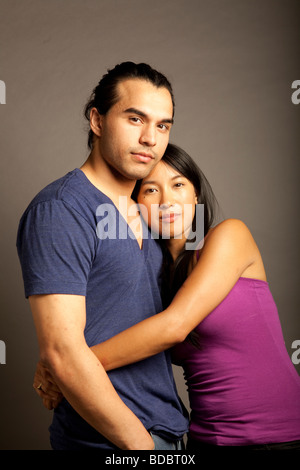 Portrait de femmes et hommes philippins ethniques couple contre fond gris. En regardant la caméra. Banque D'Images