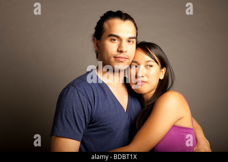 Portrait de femmes et hommes philippins ethniques couple contre fond gris. En regardant la caméra. Banque D'Images