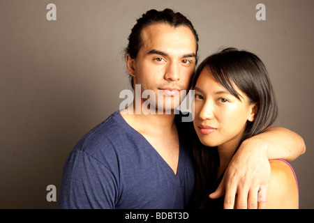 Portrait de femmes et hommes philippins ethniques couple contre fond gris. En regardant la caméra. Banque D'Images