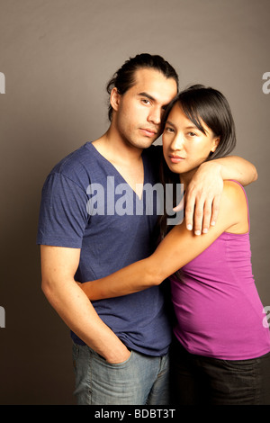 Portrait de femmes et hommes philippins ethniques couple contre fond gris. En regardant la caméra. Banque D'Images