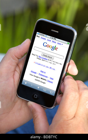 Tenir une main de l'iPhone avec Google recherche montrant sur l'écran Banque D'Images