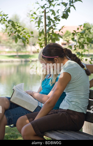 Deux filles lecture mix racialement mixtes de la diversité ethnique Caucasien hispanique discuter Bible naturel nature jeune personne de personnes 11 12 13 ans ans Myrleen Pearson Banque D'Images