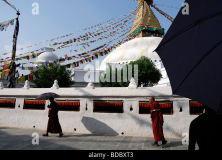 Bodhnath Bodnath stupa bouddhiste Boudhanath plus grand Katmandou Népal dôme blanc ciel bleu monks à prière marche umbrella Banque D'Images