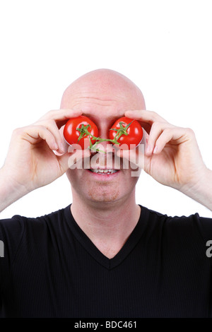 L'homme a sa tête chauve tomates devant ses yeux Banque D'Images